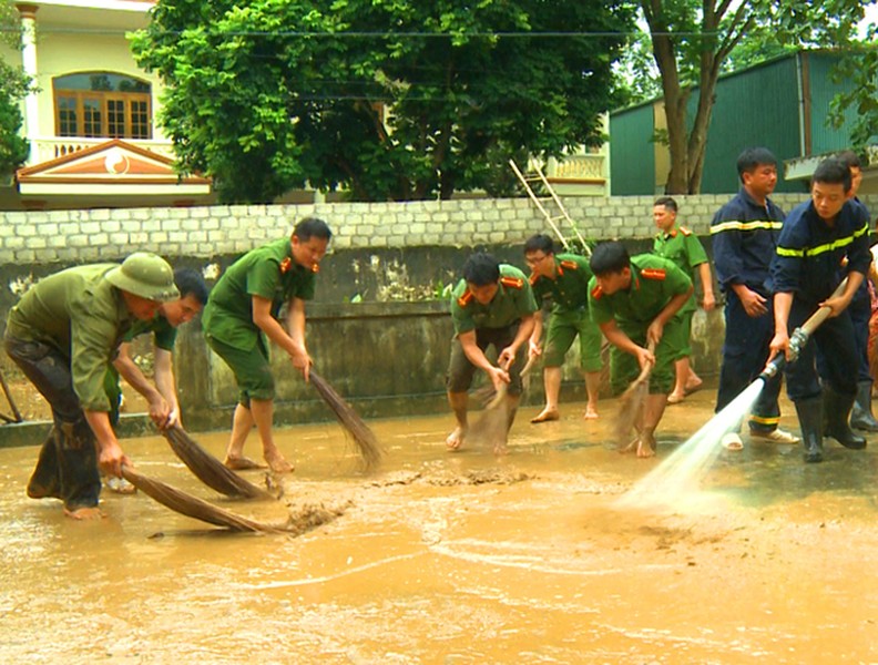 Công an dầm mình trong bùn lầy giúp người dân khắc phục hậu quả lũ lụt